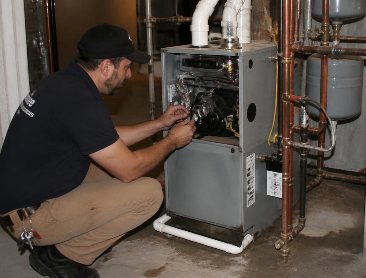 Technician servicing a residential boiler heating system